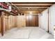 Unfinished basement with exposed beams, concrete floor, and wooden storage cabinets at 7307 S Birch St, Centennial, CO 80122