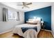 Stylish bedroom featuring a deep blue accent wall, plush bedding, and bright natural lighting at 7307 S Birch St, Centennial, CO 80122