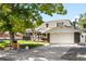 Inviting home exterior with mature trees, manicured lawn, and a two-car garage at 7307 S Birch St, Centennial, CO 80122