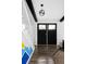 Bright entry foyer with dark wood floors, white staircase and black trimmed glass pane doors at 7307 S Birch St, Centennial, CO 80122