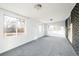 Bright living room with lots of windows, gray carpeting and brick wall accents at 7307 S Birch St, Centennial, CO 80122