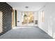 Bright living room with sliding glass doors leading to outdoor patio with gray carpeting and brick wall accents at 7307 S Birch St, Centennial, CO 80122