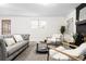 Bright living room featuring a comfortable gray sofa, modern chairs, and a sleek coffee table at 7307 S Birch St, Centennial, CO 80122