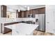 Updated kitchen features an island, stainless steel appliances, quartz countertops and dark wood cabinetry at 1170 Sugarloaf Ln, Erie, CO 80516