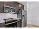 Modern kitchen showcases stainless steel appliances, a subway tile backsplash and dark wood cabinetry at 1170 Sugarloaf Ln, Erie, CO 80516