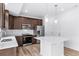 Bright kitchen features stainless steel appliances, an island with pendant lights, dark wood cabinets and white subway tile at 1170 Sugarloaf Ln, Erie, CO 80516