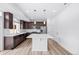 Spacious kitchen featuring stainless steel appliances, quartz countertops, and dark wood cabinetry at 1170 Sugarloaf Ln, Erie, CO 80516