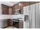 Modern kitchen with stainless steel appliances, quartz countertops, and dark wood cabinets at 1170 Sugarloaf Ln, Erie, CO 80516