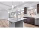 Bright kitchen featuring a center island, modern lighting, stainless steel appliances, and large windows at 1170 Sugarloaf Ln, Erie, CO 80516