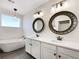 Bathroom featuring double sinks, white cabinets, large mirrors and a standalone soaking tub at 339 Rocking Chair Dr, Berthoud, CO 80513