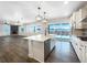 A modern kitchen with a white island, stainless appliances, and large sliding glass doors to the yard at 339 Rocking Chair Dr, Berthoud, CO 80513