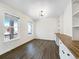 Sunlit room featuring wood floors, two windows, and a built-in desk with cabinets at 339 Rocking Chair Dr, Berthoud, CO 80513