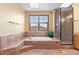 Bright bathroom featuring a soaking tub, tiled shower, and window at 9983 Cottoncreek Dr, Highlands Ranch, CO 80130