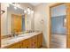 A bathroom featuring double sinks with granite countertops and wood cabinets at 9983 Cottoncreek Dr, Highlands Ranch, CO 80130