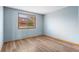 A well-lit bedroom with wood flooring and a view through a window at 9983 Cottoncreek Dr, Highlands Ranch, CO 80130