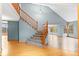 Bright entryway featuring a staircase with wooden banister and hardwood floors leading to a spacious living area at 9983 Cottoncreek Dr, Highlands Ranch, CO 80130