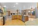 Open kitchen features hardwood floors, stainless steel appliances, and an island with bar seating at 9983 Cottoncreek Dr, Highlands Ranch, CO 80130
