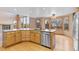 Bright kitchen features an island with bar seating, stainless steel appliances, and hardwood floors at 9983 Cottoncreek Dr, Highlands Ranch, CO 80130