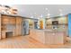 Spacious kitchen with stainless steel refrigerator, light wood cabinets, and an island featuring barstool seating at 9983 Cottoncreek Dr, Highlands Ranch, CO 80130