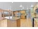Open kitchen features an island with seating, stainless steel appliances, and hardwood floors at 9983 Cottoncreek Dr, Highlands Ranch, CO 80130