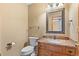 Cozy powder room with single vanity featuring granite countertops and an ornate mirror at 9983 Cottoncreek Dr, Highlands Ranch, CO 80130