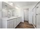 A spacious bathroom featuring wood flooring, a double vanity, and a glass enclosed shower at 250 Lark Sparrow Way, Bennett, CO 80102