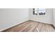A bright bedroom featuring wood flooring, a large window, and neutral paint at 250 Lark Sparrow Way, Bennett, CO 80102