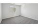 A bright bedroom featuring neutral carpeting, a large window, and neutral paint at 250 Lark Sparrow Way, Bennett, CO 80102