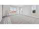 A bright bedroom featuring neutral carpeting and multiple windows providing ample natural light at 250 Lark Sparrow Way, Bennett, CO 80102