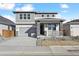 Charming two-story home featuring a stone-accented porch, gray siding, and a well-maintained front yard at 250 Lark Sparrow Way, Bennett, CO 80102