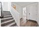 Bright foyer with wood floors, stairway, and white door, leading to other rooms in the house at 250 Lark Sparrow Way, Bennett, CO 80102