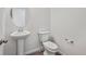 A half bathroom featuring a pedestal sink, tile flooring, and neutral paint at 250 Lark Sparrow Way, Bennett, CO 80102