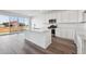 Modern kitchen with white cabinets, quartz countertops, stainless steel appliances, and an island at 250 Lark Sparrow Way, Bennett, CO 80102