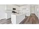 Bright, open kitchen featuring white cabinetry, an island with a sink, and stainless steel appliances at 250 Lark Sparrow Way, Bennett, CO 80102