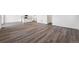 Open living area with wood-look floors flowing into the kitchen with an island at 250 Lark Sparrow Way, Bennett, CO 80102