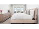 Inviting bedroom featuring a plush pink bed frame, soft bedding, and large windows with scenic views at 2851 W 52Nd Ave # 404, Denver, CO 80221