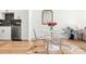 Dining area with clear chairs and modern decor, next to a well-equipped kitchen and sunlit living space at 2851 W 52Nd Ave # 404, Denver, CO 80221