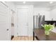 View of the kitchen and entryway highlighting white cabinets and stainless steel appliances at 2851 W 52Nd Ave # 404, Denver, CO 80221