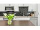 Modern kitchen boasts stainless steel appliances, sleek white cabinetry, and a unique backsplash at 2851 W 52Nd Ave # 404, Denver, CO 80221