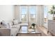 Bright living room with a gray sofa, glass table, and large windows at 2851 W 52Nd Ave # 404, Denver, CO 80221