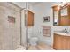Bathroom featuring a glass enclosed shower, toilet, sink with vanity and wood cabinetry at 4158 Wild Flower Ct, Evergreen, CO 80439