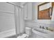 Bright bathroom featuring subway tile, white vanity, and decorative mirror reflecting the wood door at 4158 Wild Flower Ct, Evergreen, CO 80439