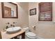 Elegant powder room with vessel sink, bronze fixtures, and window with wooden shutters at 4158 Wild Flower Ct, Evergreen, CO 80439