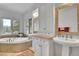 Bright and airy bathroom featuring a soaking tub with a view, dual vanities, and ample storage at 4158 Wild Flower Ct, Evergreen, CO 80439