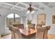 Elegant dining room features a coffered ceiling, arched window with mountain views, and a beautiful chandelier at 4158 Wild Flower Ct, Evergreen, CO 80439