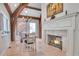Charming dining room features wooden beam ceilings, travertine floors, and a fireplace with VOCATVS inscription at 4158 Wild Flower Ct, Evergreen, CO 80439