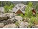 An exterior elevation shows a luxury home on a rocky hillside with mature trees at 4158 Wild Flower Ct, Evergreen, CO 80439