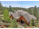 Stunning architectural design highlighting covered patio with wooden beams and a serene mountain backdrop at 4158 Wild Flower Ct, Evergreen, CO 80439