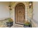 Inviting front door with stone surround, decorative lighting, and potted plants for a welcoming entrance at 4158 Wild Flower Ct, Evergreen, CO 80439