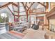 Spacious living room featuring beamed ceilings, a fireplace, and ample natural light at 4158 Wild Flower Ct, Evergreen, CO 80439